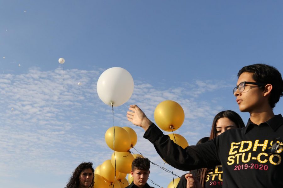 Jovan Guzman, 11, releases a white balloon into the blue sky. A balloon was released for each victim of Saturdays shooting as a bell sounded 22 times.