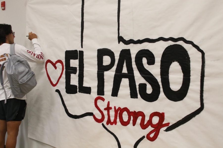 Students sign the memorial banner in the cafeteria on the second anniversary of the Aug. 3 Wal-Mart shooting. 