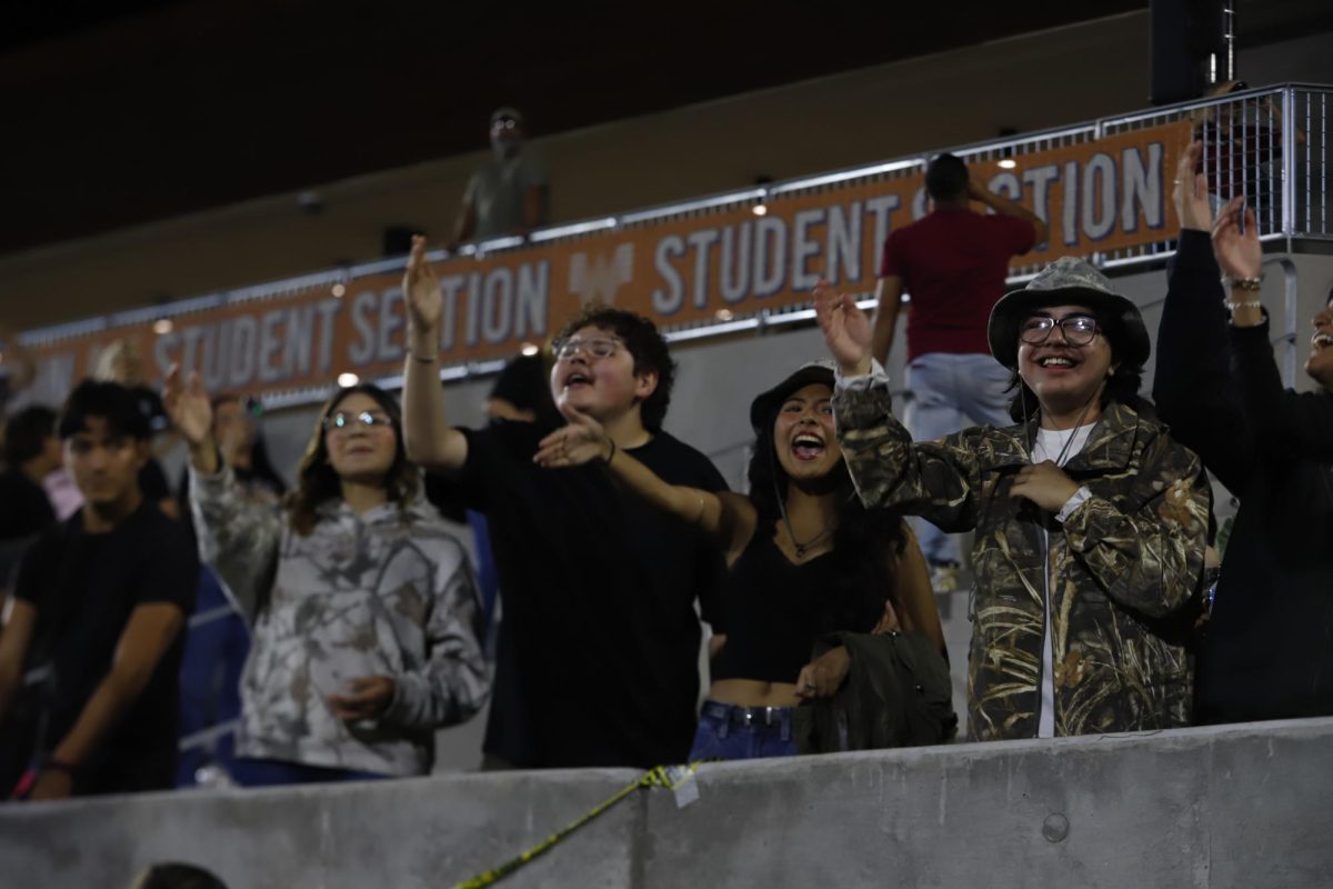 Smiling to the field, senior Miley Pinon and juniors Martin Dominguez and Gabriel Lopez do the traditional Aztec chop on Oct. 10 at SAC 2. Pinon was excited to see the win due to the El Dorado and Americas rivalry. “This was by far the most hype game I have ever been to. I had the best time sharing stories with my friends and cheering on our team," Pinon said.